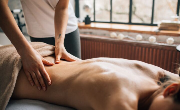Masaż relaksacyjny, dłonie na plecach przy oknie, Salon Magnolia